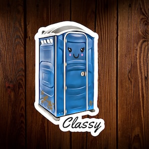 May include: A blue portable toilet with a white door and a smiling face drawn on it. The toilet is on a wood background and the text "Classy" is written below it.