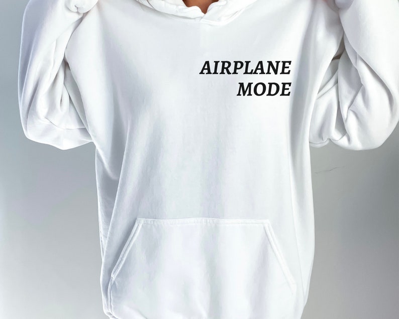Puede incluir: Sudadera con capucha blanca con el texto "AIRPLANE MODE" impreso en la parte delantera.