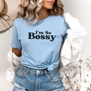 May include: A light blue t-shirt with the text "I'm So Bossy" in black.
