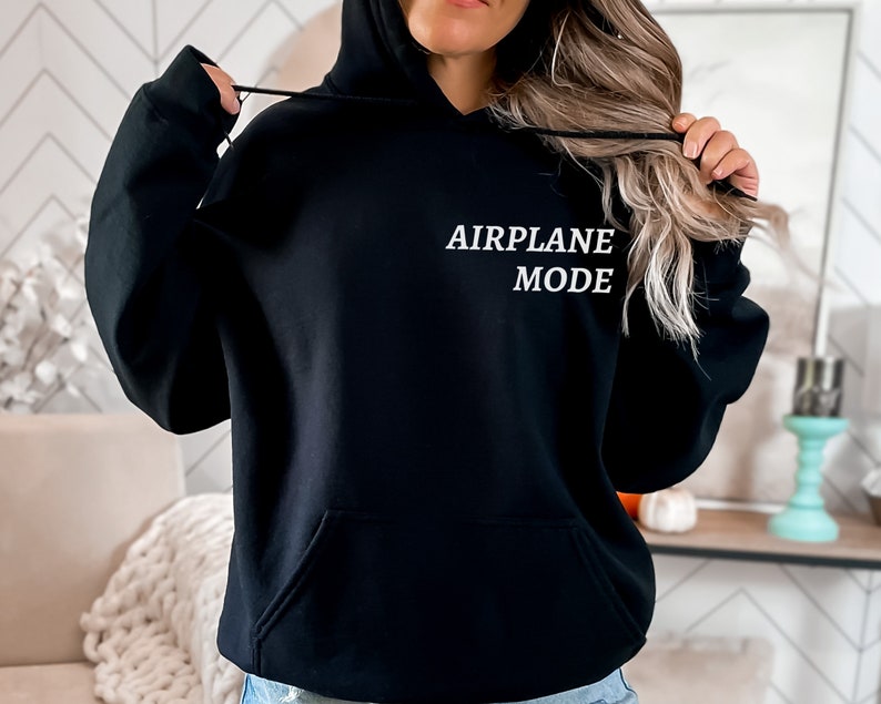 Puede incluir: Sudadera con capucha negra con el texto "AIRPLANE MODE" en letras blancas.