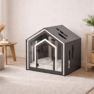 May include: A dark gray pet house with a gabled roof design, featuring a clear acrylic front panel with a white-trimmed door frame. The structure includes vertical side cutouts and contains a plush, tufted white cushion inside for comfort.