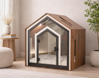 May include: A wooden pet house with a gabled roof and a clear glass front door featuring a black frame. The structure includes a white interior trim, a soft white cushion inside, and a rectangular cutout on the roof for ventilation or light.