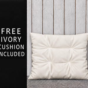 This may include: a square pillow in an ivory tone. The left side has the text "FREE IVORY CUSHION INCLUDED" printed on it; it's an IVORY colored pillow.