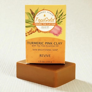 May include: A bar of brown soap with a matching box. The box is yellow and orange with the words "TopiGold TURMERIC PINK CLAY SOAP" and "REVIVE". The soap is 5.5 oz.