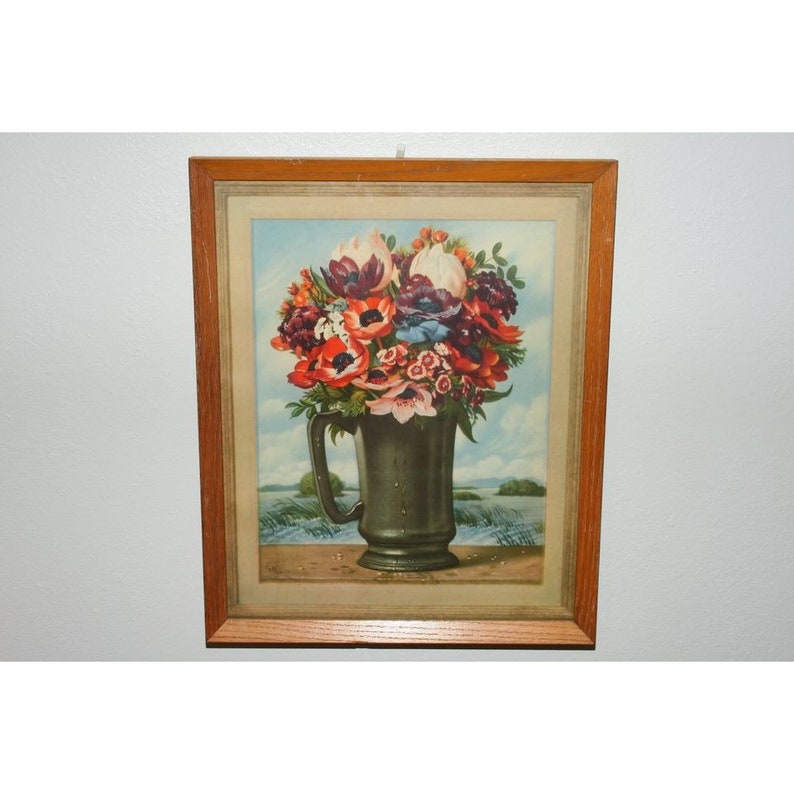 May include: A framed vintage print of a still life featuring a bouquet of colorful flowers in a green ceramic pitcher. The flowers include red, pink, white, and purple blooms. The background is a light blue sky with a hint of green foliage.