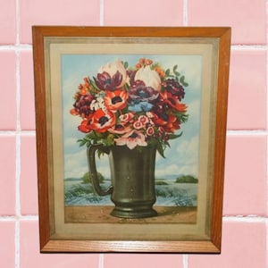 May include: A framed vintage print of a bouquet of colorful flowers in a green ceramic pitcher. The flowers include red, pink, white, and purple blooms. The background is a light blue sky with a green field.