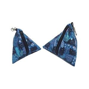 May include: Two blue triangle-shaped zippered pouches with a black cat and floral print. The smaller pouch has a silver zipper pull and the larger pouch has a silver ring.