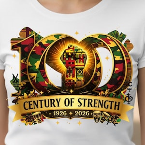 May include: White t-shirt featuring a vibrant graphic celebrating a century of strength. The design includes a stylized "100" with camouflage and gold accents, a raised fist, and the text "CENTURY OF STRENGTH 1926 + 2026".