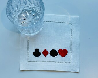 Peut inclure: Serviette de cocktail en lin blanc avec des motifs brodés de cartes à jouer noires et un cœur rouge.