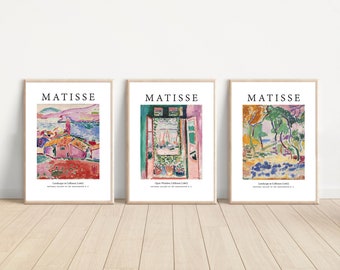 Könnte beinhalten: Drei gerahmte Kunstdrucke mit farbenfrohen Landschaftsbildern von Matisse. Jeder Druck hat einen weißen Rand und einen hellen Holzrahmen. Oben auf jedem Druck steht "MATISSE" in schwarzem Text. Der untere Teil jedes Drucks enthält den Titel und das Datum des Gemäldes.