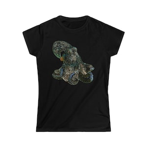Könnte beinhalten: Schwarzes T-Shirt mit einer detaillierten Illustration eines Oktopus. Der Oktopus hat ein gesprenkeltes Muster in Blau-, Grün- und Beigetönen. Die Tentakel sind ausgebreitet, und das Design ist auf dem T-Shirt zentriert.