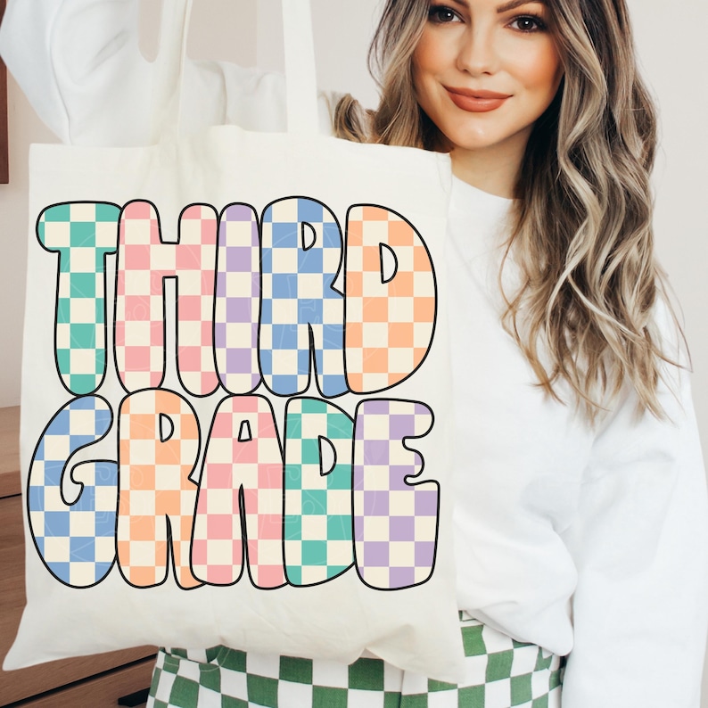 May include: A white canvas tote bag with the words "THIRD GRADE" in colorful checkered letters. The letters are outlined in black and have a retro, bubble-like style.