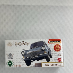 Könnte beinhalten: Ein Matchbox-Spielzeugauto des Ford Anglia von 1962, aus der Harry-Potter-Serie. Das Druckguss-Metallauto ist hellblau mit dem Kennzeichen 7990 TD. Die Verpackung enthält den Text "NEW NOUVEAU 2024".