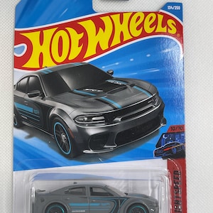 May include: A Hot Wheels die-cast model of a gray '20 Dodge Charger Hellcat. The car has blue accents and is packaged in a blue and red card with the Hot Wheels logo and "NIGHTSPEED" printed on it. The package also includes the text "GUARANTEED FOR LIFE".