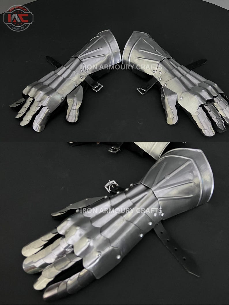 Op de afbeelding: Een paar gepolijste stalen handschoenen met beweeglijke vingers en handbescherming. De handschoenen hebben een metallic glans en zijn vastgezet met leren riemen en gespen. De tekst "IRON ARMOURY CRAFTS" is zichtbaar.