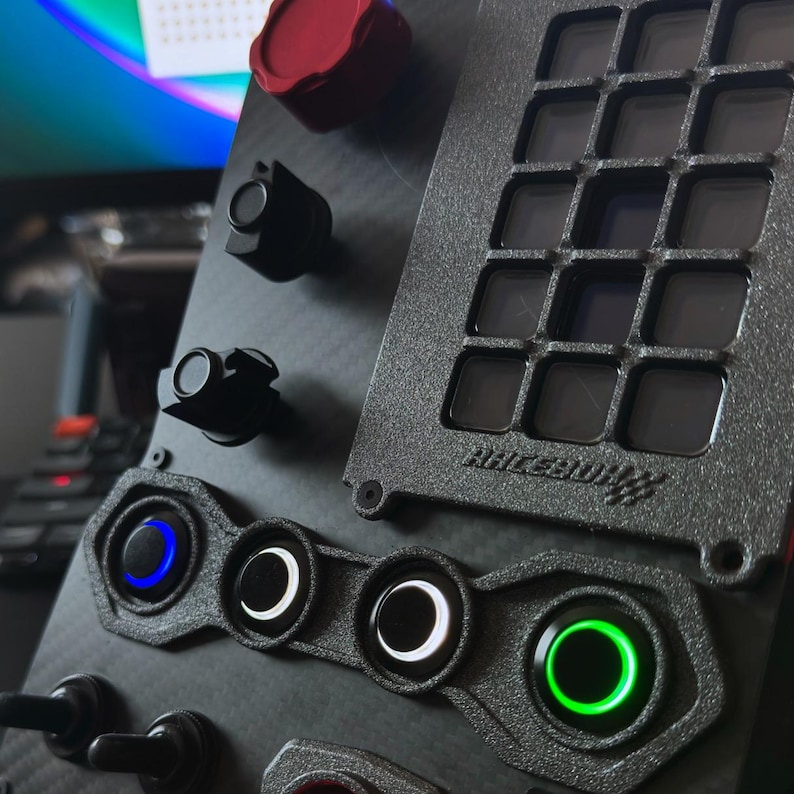 A black panel with a grid of 16 buttons, three round toggle switches with white and blue LED lights, and a red toggle switch. The panel is labeled "ACCESSORY".