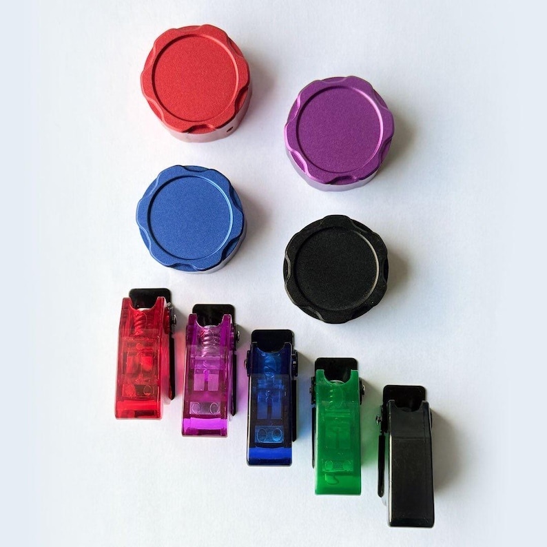 Assortment of colorful round metal knobs and small plastic toggle switches in red, purple, blue, black, pink, green, and black.