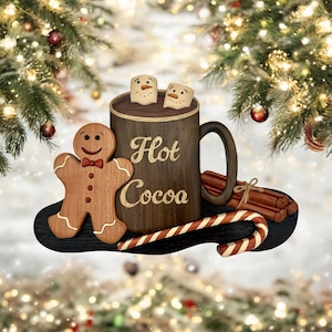 May include: Wooden ornament shaped like a mug of hot cocoa with marshmallows, a gingerbread man, candy canes, and cinnamon sticks. The mug is brown and says "Hot Cocoa".