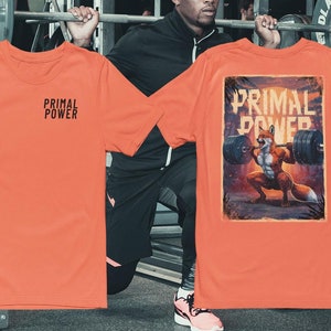 Puede incluir: Dos camisetas naranjas con el texto "Primal Power" en ellas. Una camiseta tiene un gráfico de un zorro levantando pesas.
