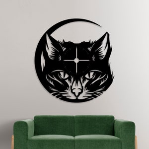 May include: Black metal cat-shaped wall clock. The clock face is integrated into the cat's face, with a circular design and simple hands. The cat's head is framed by a crescent shape. The clock is mounted on a white wall above a green sofa.