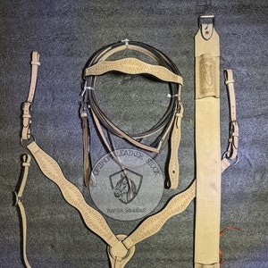 Conjunto de cabeçada, coleira e rédeas de couro ocidental, feito à mão e trabalhado à mão, com cinto nas costas.
