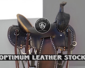 May include: A brown leather saddle with white stitching and a tooled design. The saddle is on a metal stand and has a brown leather seat with a gold trim. The saddle is labelled "Optimum Leather Stock Horse Saddles".
