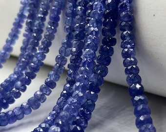 May include: A strand of blue gemstone beads, faceted and with a slightly irregular shape. The beads are strung on a clear thread and are approximately 4mm in diameter.