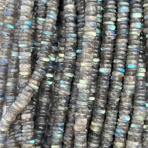 May include: A strand of gray and iridescent labradorite gemstone beads. The beads are faceted and have a smooth, polished finish. The beads are strung on a clear elastic cord.