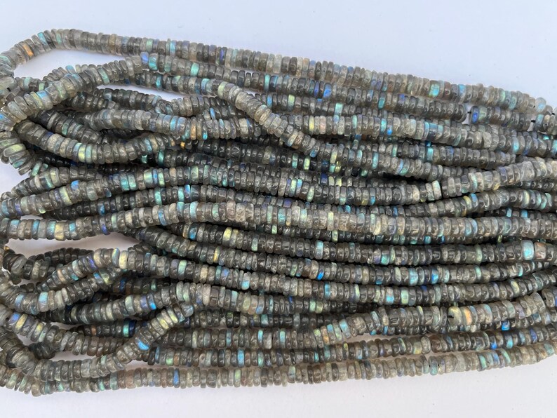 May include: A strand of gray labradorite gemstone beads. The beads are small and round, with a slight iridescent sheen.