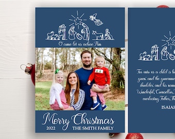 May include: A navy blue Christmas card featuring a family photo and a nativity scene illustration. The card includes the text "Merry Christmas 2022 The Smith Family" and a Bible verse. The card is decorated with a red ornament and a candy cane.