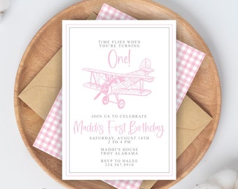 May include: Pink and white aeroplane themed first birthday party invitation with the text "Time flies when you're turning One!" and "Maddi's First Birthday" with details for the party including date, time, location, and RSVP information.
