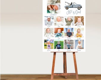 May include: A white poster board with a blue tow truck illustration and the text "JP is One!"  The poster board is divided into 12 squares, each containing a photo of a baby boy at different ages. The photos are labeled with the age of the baby, from newborn to twelve months.