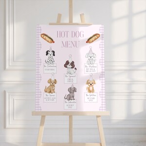 Op de afbeelding: Een roze hotdogmenu op een houten ezel. Het bord bevat illustraties van honden met feesthoeden, die elk een andere hotdogoptie vertegenwoordigen. De tekst luidt "HOT DOG MENU" en geeft verschillende hotdogcombinaties weer.