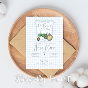 Puede incluir: Una invitación a una fiesta de bienvenida al bebé de color azul y blanco a cuadros vichy con una ilustración de un tractor verde y negro. El texto dice "On Deere Baby is Almost Here" y "Join us for a Baby Shower Honoring Anna Marie". La fecha y la hora de la fiesta de bienvenida al bebé se indican como "Sábado, 5 de mayo de 2024 a las 2:00 PM". La ubicación se indica como "First Baptist Troy, AL". La invitación también incluye el texto "Anna is registered at 234.567.8910".