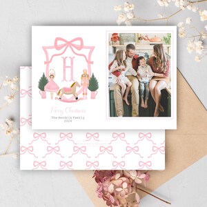 May include: Pink Christmas cards with a family photo and a decorative design. The front card features a pink bow frame with the letter "H", a ballerina, a rocking horse, a nutcracker, and Christmas trees. The text reads "Merry Christmas" and "The Hendrix Family 2024".