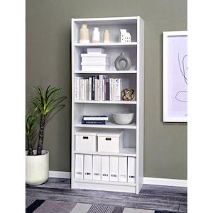 May include: A tall, white bookshelf with multiple shelves filled with decorative items, books, and storage boxes. The shelves display a variety of objects, including vases, books, and decorative boxes. A potted plant is visible to the left of the bookshelf.