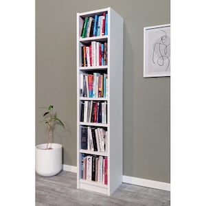 May include: A tall, white bookshelf filled with various books of different sizes and colors. The bookshelf has six shelves and is positioned against a gray wall. A small potted plant and a framed abstract art piece are also visible.