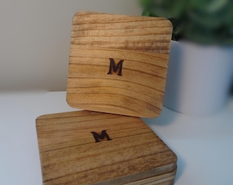 Puede incluir: Dos cajas de madera con la letra "M" quemada en la parte superior. Las cajas están apiladas una encima de la otra.