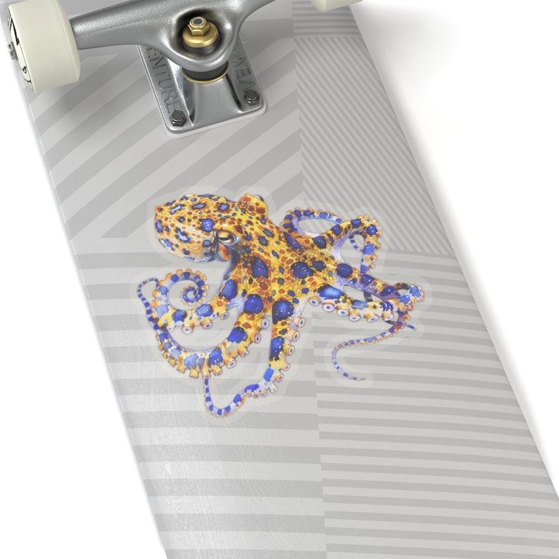 May include: A skateboard deck with a graphic of a blue-ringed octopus with yellow spots. The octopus is on a white background with gray stripes.