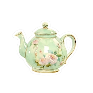 Könnte beinhalten: Eine grüne Teekanne mit Blumenmuster. Die Teekanne hat einen goldenen Rand und einen weißen Hintergrund. Die Blumen sind rosa und weiß.
