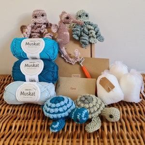 May include: A crochet kit with blue and teal yarn, a pattern, and two crocheted sea turtle toys. The kit also includes stuffing, eyes, and a crochet hook.