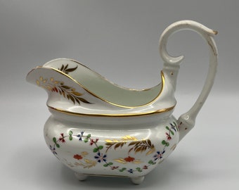 Jarra antigua de porcelana Derby para crema (1782-1825), pintada a mano con motivos florales y dorada.