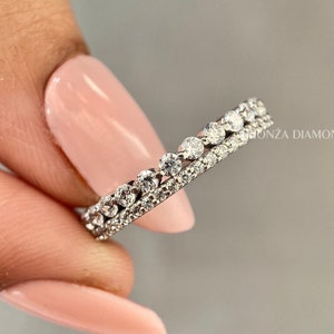 May include: A thin silver band with two rows of small, clear diamonds.