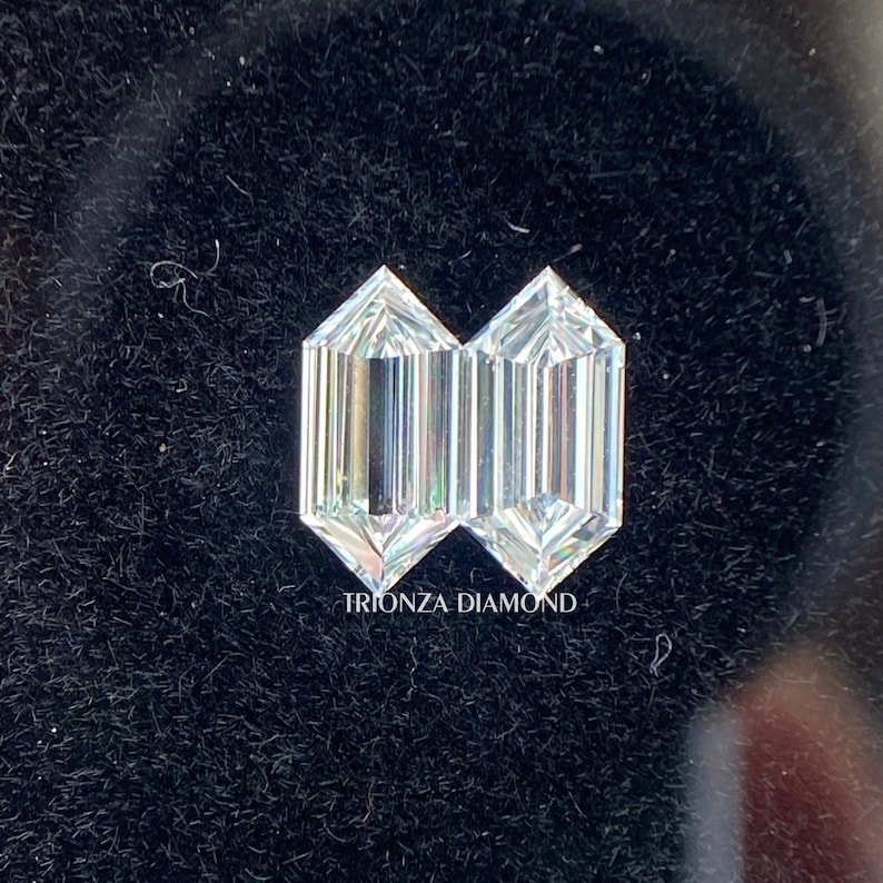 May include: Two clear, octagon-shaped diamonds, side by side, on a black background. The text "TRIONZA DIAMOND" is printed below the diamonds.