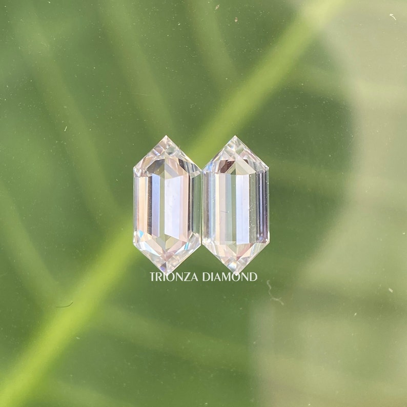 May include: Two clear, octagon-shaped diamonds, side by side, on a green background. The text "TRIONZA DIAMOND" is below the diamonds.