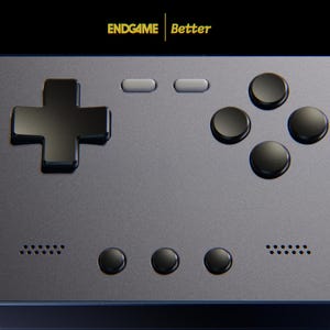 May include: A handheld gaming console with a matte dark gray finish, featuring a black directional pad, four black circular action buttons, two light gray rectangular buttons, and three black circular buttons. The screen displays the text ENDGAME Better.