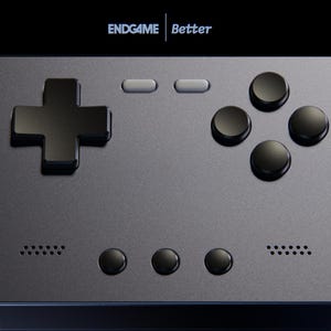 Op de afbeelding: Close-up van een handheld gaming-apparaat met een grijze behuizing en zwarte knoppen. Het apparaat heeft een D-pad, vier actieknoppen en twee kleinere knoppen. De tekst "ENDGAME Better" wordt bovenaan weergegeven.