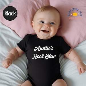 Puede incluir: Un body de beb&eacute; negro con texto blanco que dice "Auntie's Rock Star".