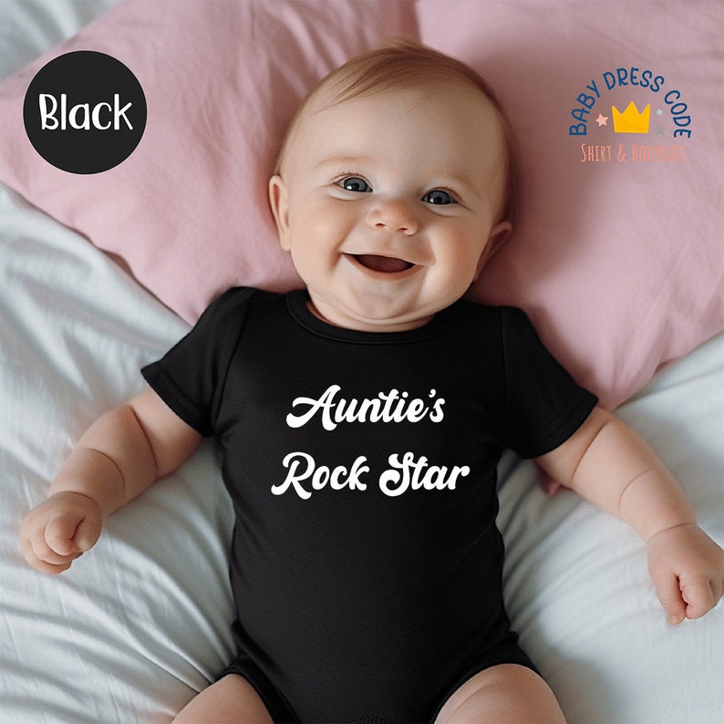 Puede incluir: Un body de beb&eacute; negro con texto blanco que dice "Auntie's Rock Star".
