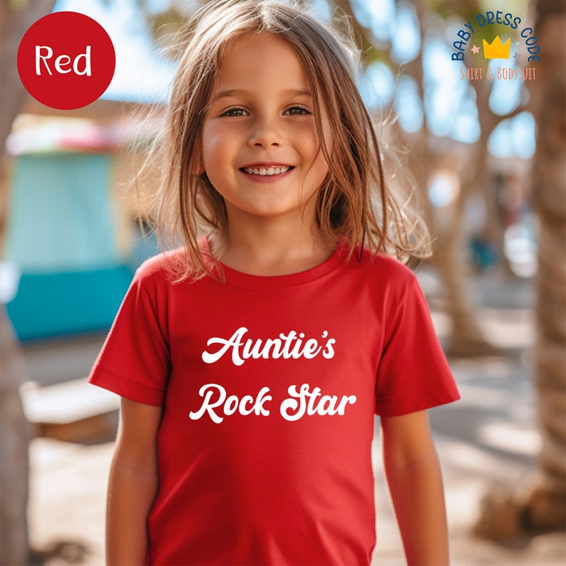 a little girl that is wearing a red shirt